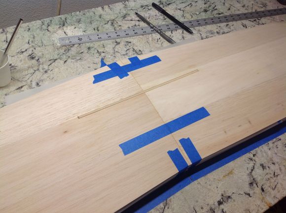 Epoxy was spread in the slot and wing roots, the wings were then taped together and to the master shucks. Epoxy was brushed on the wing joiner which is made from 1/8" lite ply and the joiner is slid into place. 