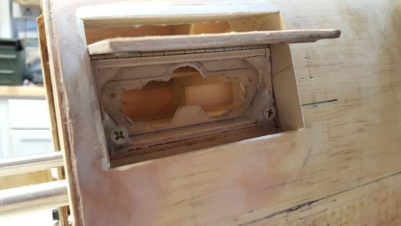 I checked for fit into the fuselage. I had to cut out some of a shelf I installed earlier and I mounted the switch box securely with epoxy. There were large gaps around the edges so I installed 1/32” plywood strips to form a clean and solid frame that fit to the hatch door. 