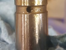 Oil pump pressure relief valve piston, you can see a piece of aluminum towards the top.  This had wedged the piston slightly open causing the delayed oil pressure on cold start and the lower than normal pressure.  I had to force the piston out of the bore