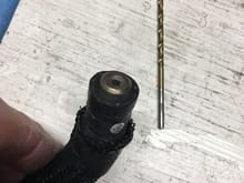 Here I've pulled the restricter to the end of the hose, so it's only starting to protrude. The restricter is essentially a brass bead. The outer diameter of the bead matches the inner diameter of the hose, and the center hole determine the amount of water flow. The 7/64"m drill bit was used to measure the center hole diameter.