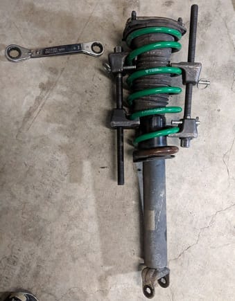 Using spring-compressors rented from AutoZone to remove the springs from the struts, early 2019