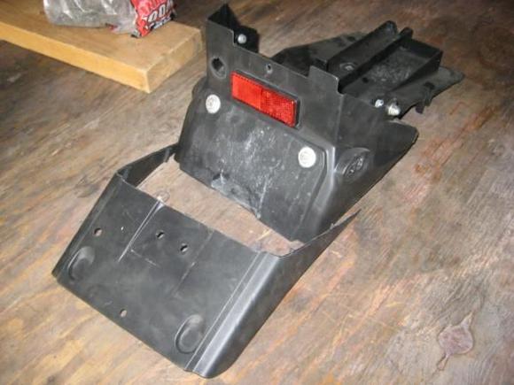 removed portion of seat undertray, shows mud flap cut off