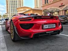 Red Porsche 918 Spyder Weissach with gold rims.