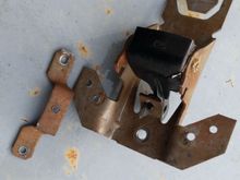 bracket rivets drilled out and bracket sitting next to the handle