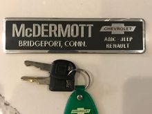 Original keys with dealer key chain, along with dealer bumper advertisement 