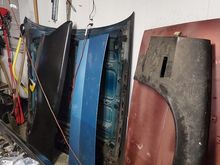 Far Left to Right: Passenger 1/4, Original Hood, Hatch Lid w/ 3rd Brake Light Provision, Replacement Hood & Driver Side Fender. I've had that Fender a good 18 years. Drove to The Paddock when it was still in business here in Indiana to get it. EDP coating has started to rust over the years.