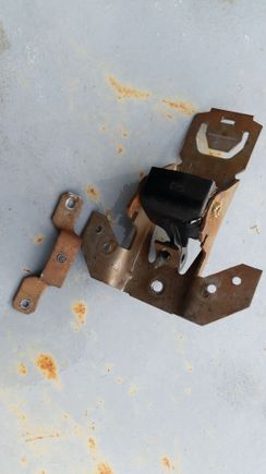 bracket rivets drilled out and bracket sitting next to the handle