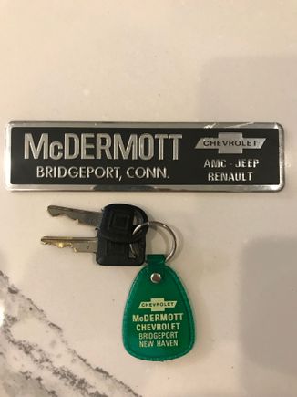 Original keys with dealer key chain, along with dealer bumper advertisement 