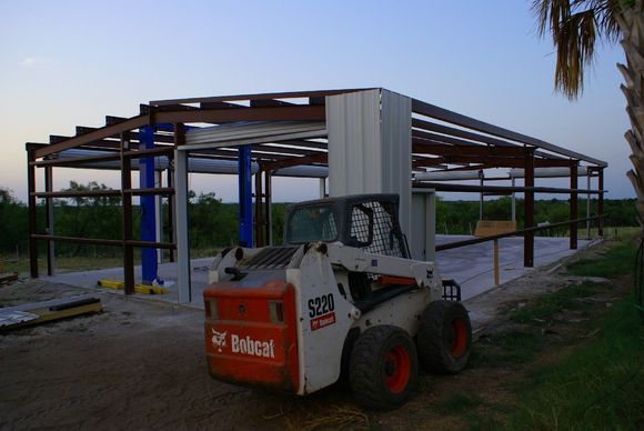 This is from a couple of weeks ago, but you can see the lift.  Now both long sides are done.  Probably take about 6 hours to finish the ends and trim, then we can get going on the roof.  After that some floor epoxy, and we're good to go.