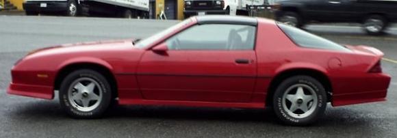 After Restoration 85 Camaro Driver Side View w/  Spoiler, GFX and Stock Paint.