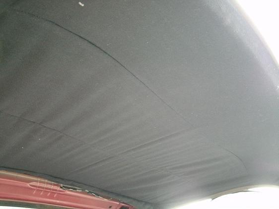 Headliner wringles, from the passenger side. Shows liner not attached to rear window. It's stuff up under the liner at the back.