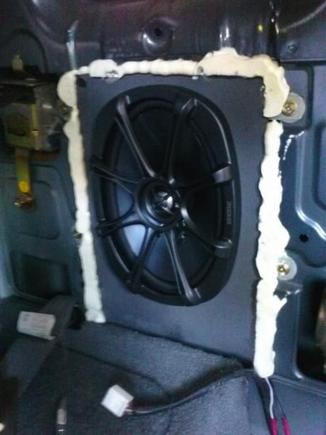 Sealed with expanding foam, speaker mounted to MDF board and re-used original mounting brackets.