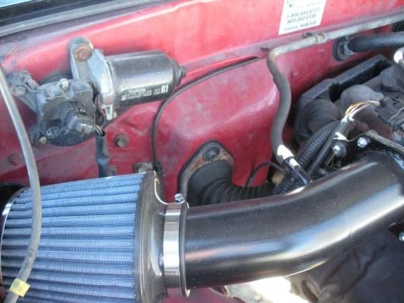 Just behind the intake pipe you can see the 97 engine harness passing through the firewall in a new hole.  there was a factory gromet there and i just enlarged the opening.